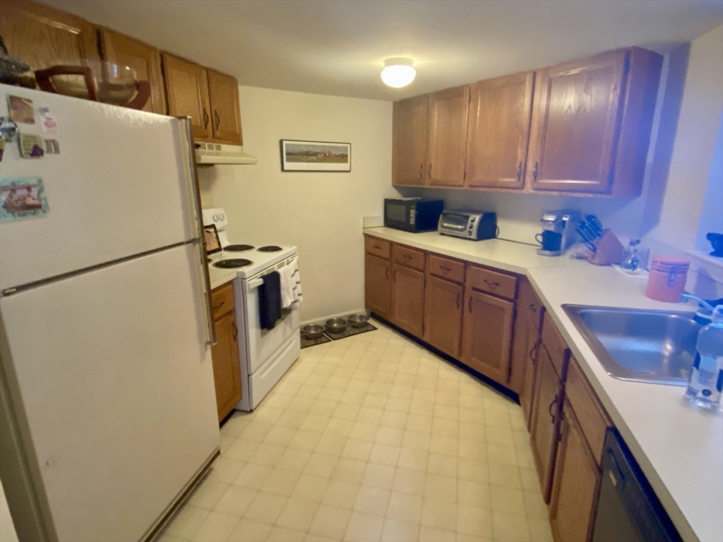 215 Trailside Way, Unit 215 Ashland, MA 01721 - Photo 9 of 15 a kitchen with a refrigerator sink stove and cabinets
