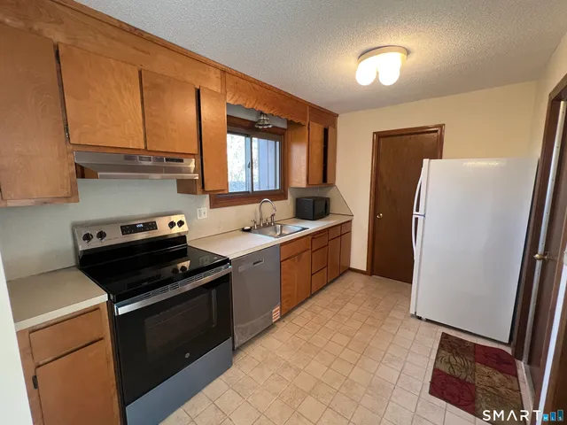 a kitchen with a stove a sink and a window