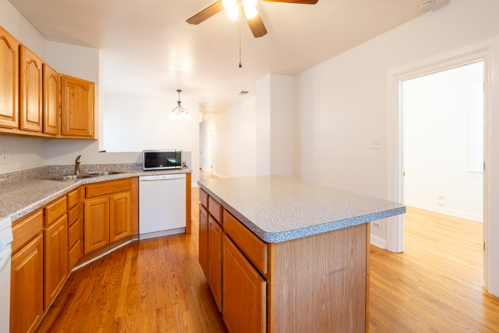 1920 West School Street Chicago, IL 60657 - Photo 23 of 36 a kitchen with granite countertop a sink cabinets and wooden floor