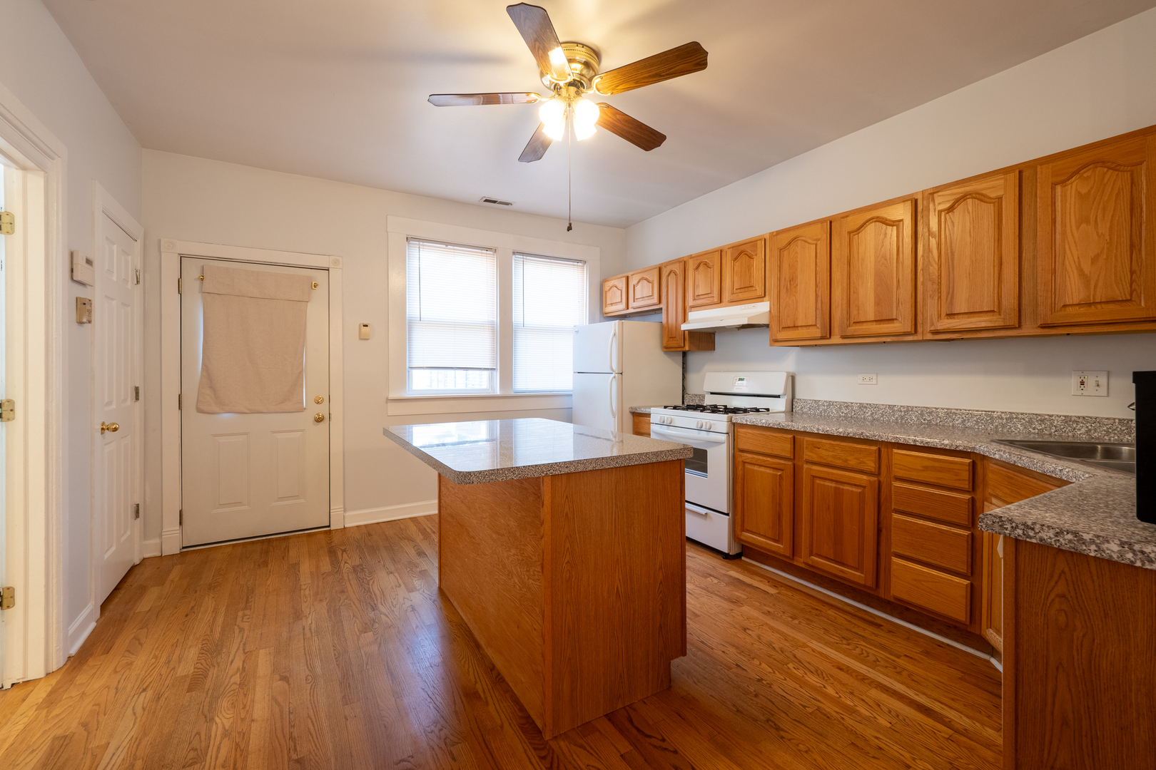 1920 West School Street Chicago, IL 60657 - Photo 24 of 36 a kitchen with stainless steel appliances granite countertop wooden floors a stove and a refrigerator