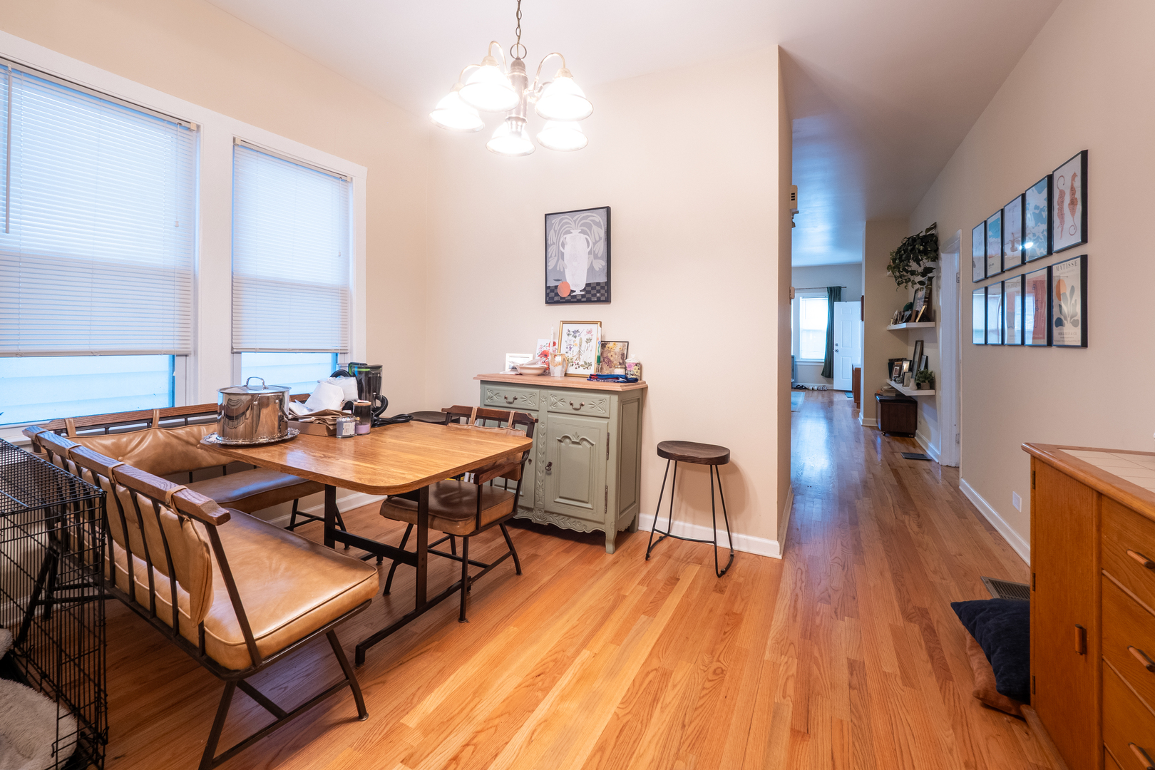 1920 West School Street Chicago, IL 60657 - Photo 9 of 36 a dining room with wooden floor a chandelier a wooden table and chairs