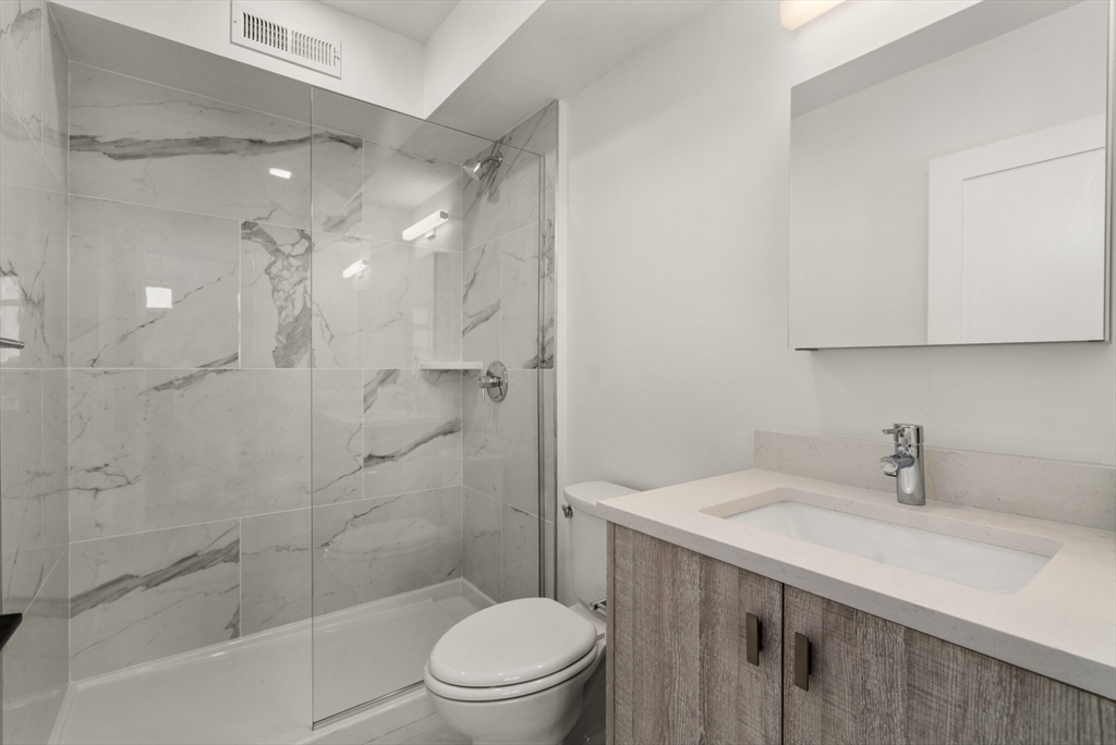 917 Bennington Street, Unit 301 Boston, MA 02128 - Photo 12 of 17 a bathroom with a sink a toilet and shower