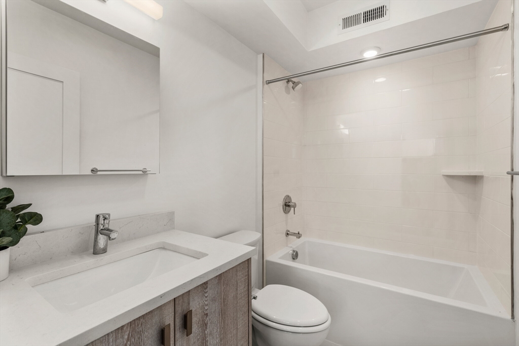 917 Bennington Street, Unit 301 Boston, MA 02128 - Photo 13 of 17 a bathroom with a granite countertop sink toilet and shower