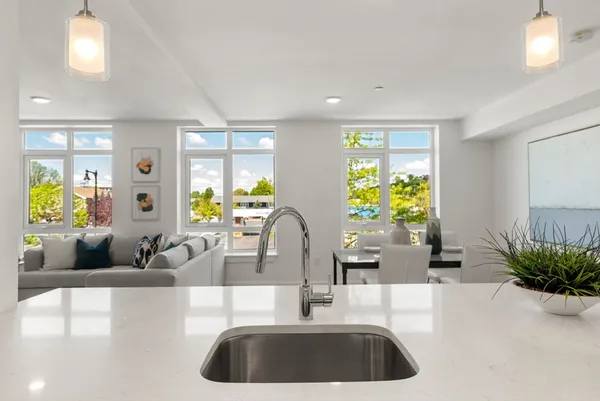 a kitchen with granite countertop a couch a potted plant and a large window