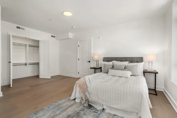 a bedroom with a bed and a refrigerator