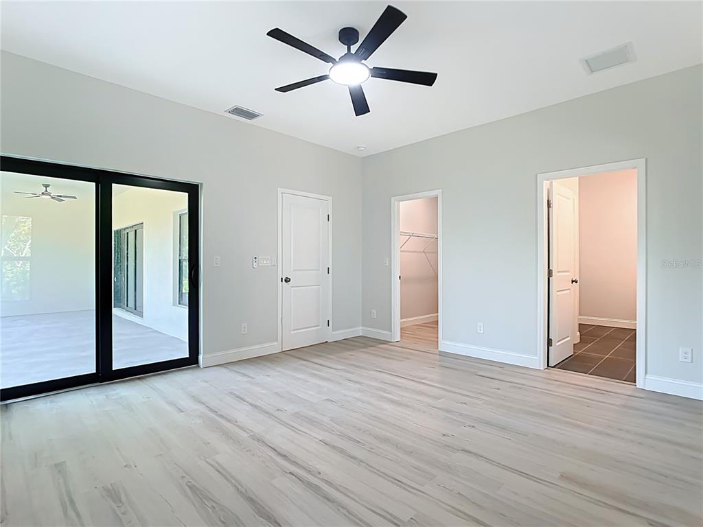 6231 Rowe Street Englewood, FL 34224 - Photo 18 of 35 a view of an empty room with wooden floor and a ceiling fan