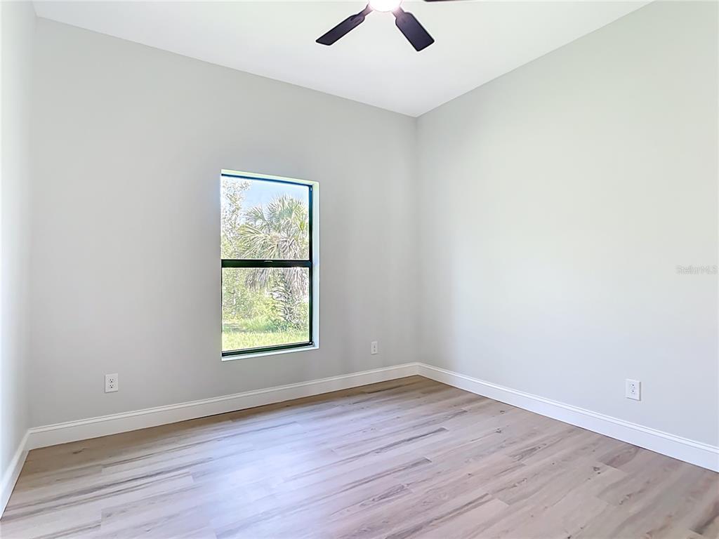 6231 Rowe Street Englewood, FL 34224 - Photo 26 of 35 an empty room with wooden floor and window