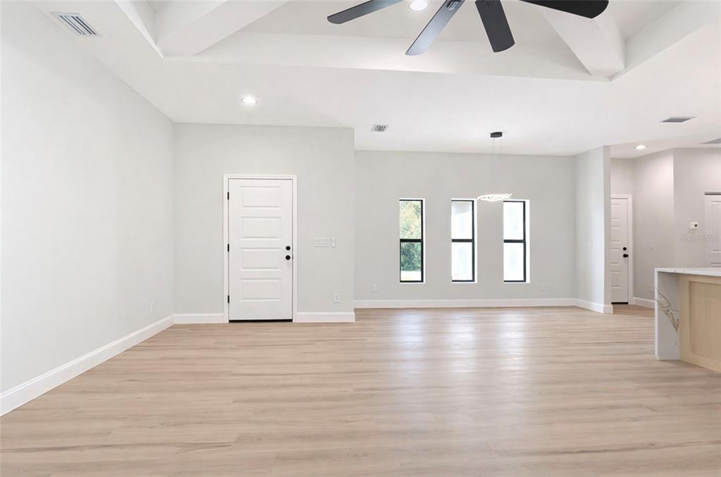 6231 Rowe Street Englewood, FL 34224 - Photo 5 of 14 an empty room with wooden floor and windows