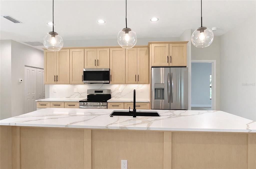 6231 Rowe Street Englewood, FL 34224 - Photo 6 of 14 a kitchen with kitchen island a refrigerator and a sink