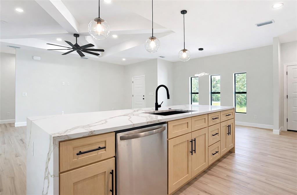6231 Rowe Street Englewood, FL 34224 - Photo 7 of 14 a kitchen with a sink chandelier and white cabinets