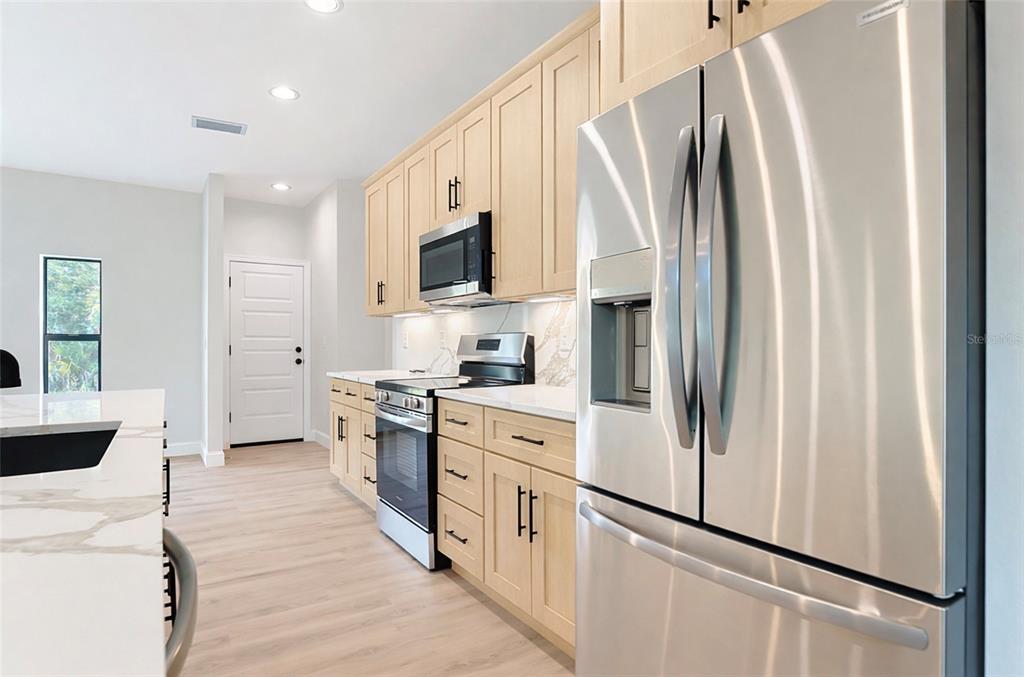 6231 Rowe Street Englewood, FL 34224 - Photo 8 of 14 a kitchen with stainless steel appliances a refrigerator sink and microwave