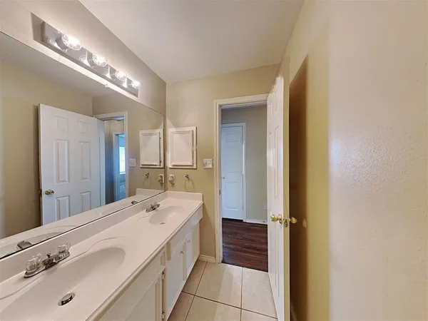 a spacious bathroom with a double vanity sink and mirror