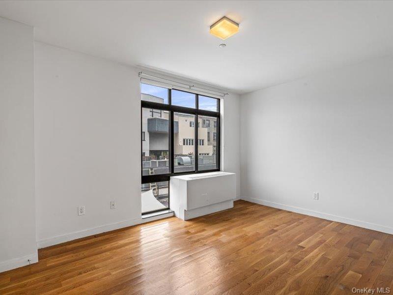 14 Hope Street, Unit 3F Brooklyn, NY 11211 - Photo 12 of 18 an empty room with wooden floor and windows
