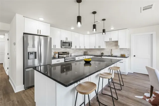 a spacious bathroom with a double vanity sink a mirror and a shower