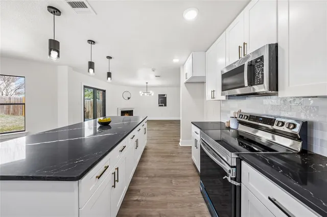 a large kitchen with stainless steel appliances lots of counter space and a sink