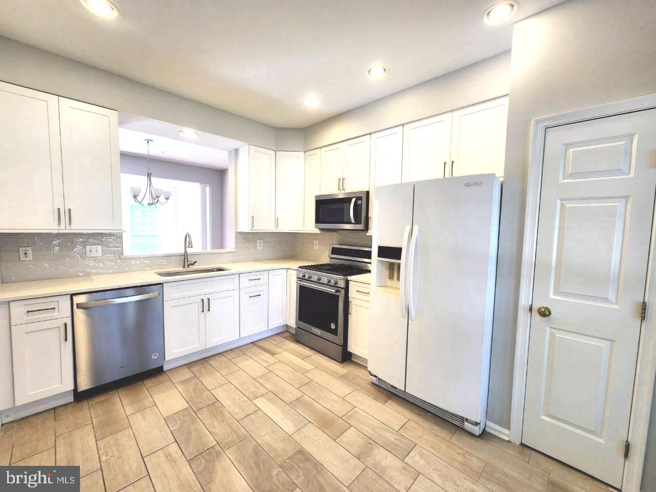 5992 Autumn Spell Elkridge, MD 21075 - Photo 8 of 30 a large kitchen with a refrigerator a sink a stove a microwave and cabinets