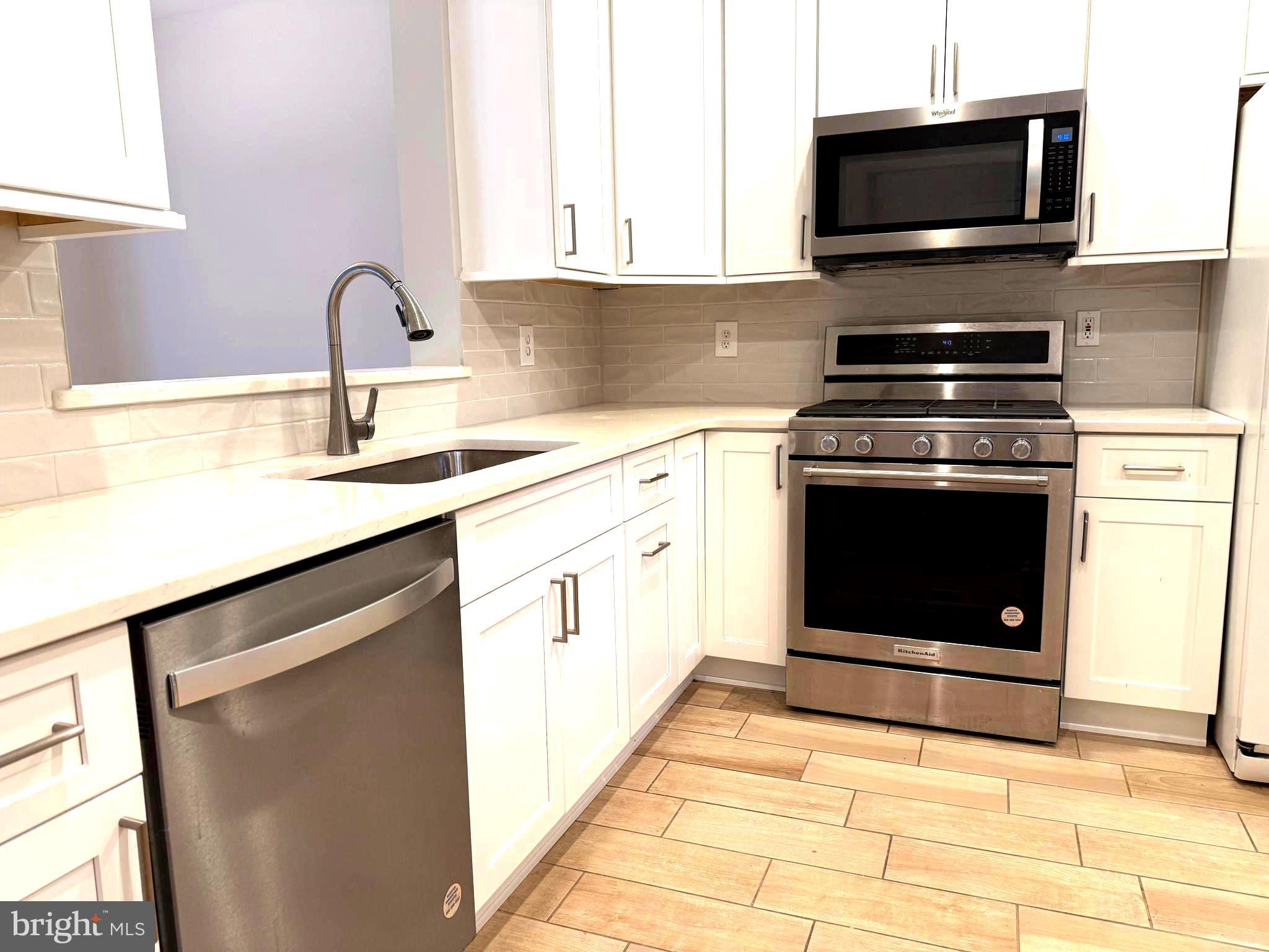 5992 Autumn Spell Elkridge, MD 21075 - Photo 9 of 30 a kitchen with stainless steel appliances a stove a sink and a microwave