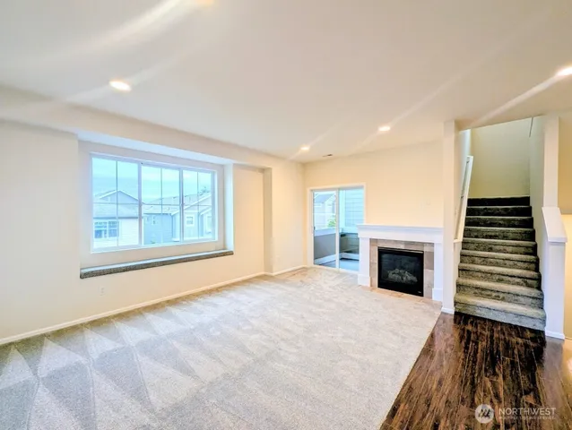 a view of an empty room with a fireplace and a window
