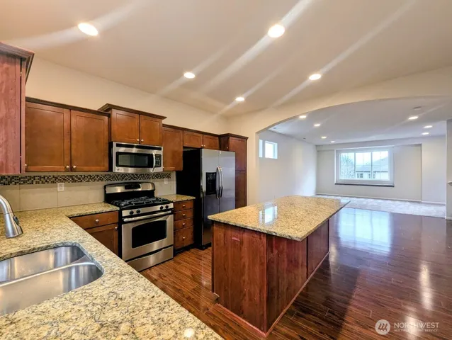 a kitchen with stainless steel appliances granite countertop a sink stove and refrigerator
