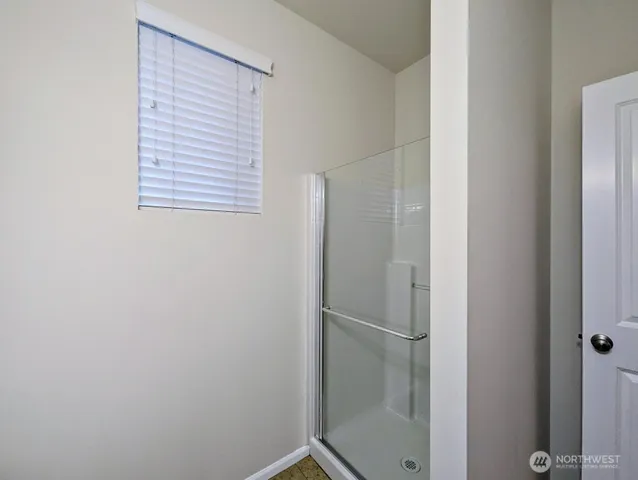 a bathroom with a glass shower door
