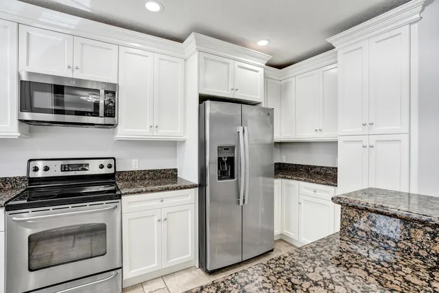 a kitchen with stainless steel appliances granite countertop a stove microwave and refrigerator