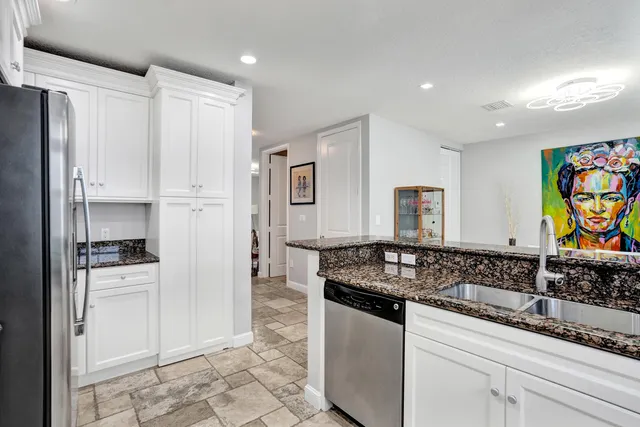 a kitchen with stainless steel appliances kitchen island granite countertop a table and chairs in it