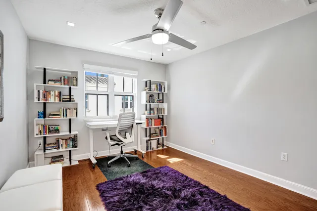 a view of a white house with a large space and large trees