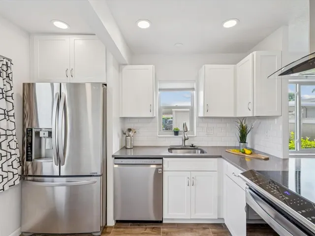 a kitchen with a refrigerator sink and cabinets