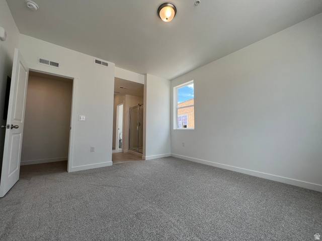 717 West W Coho Lane South, Unit 2F302 Midvale, UT 84047 - Photo 18 of 22 Carpeted room featuring a single window, overhead lighting, and an adjacent open doorway revealing a shower enclosure