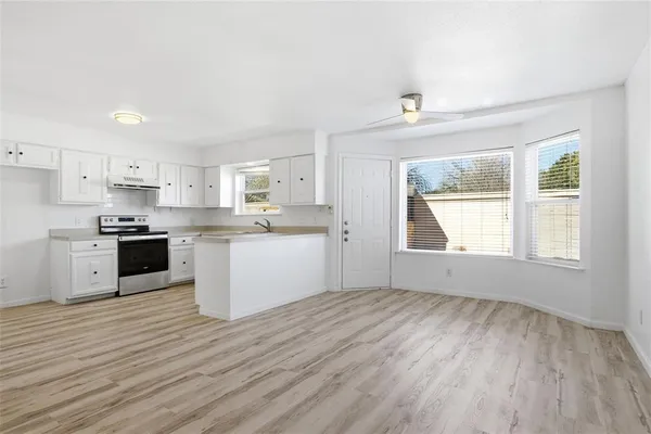 a kitchen with wooden floors and white appliances