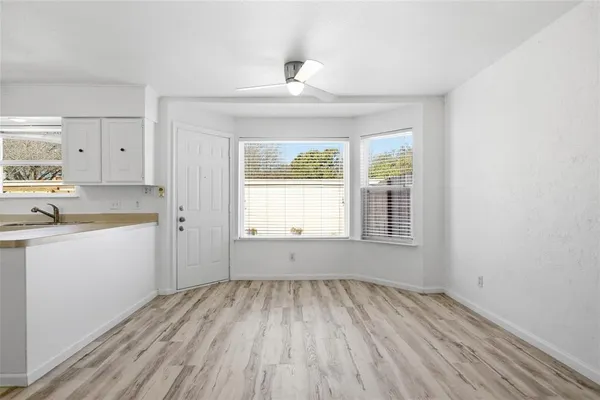 a view of a kitchen with wooden floor and a window