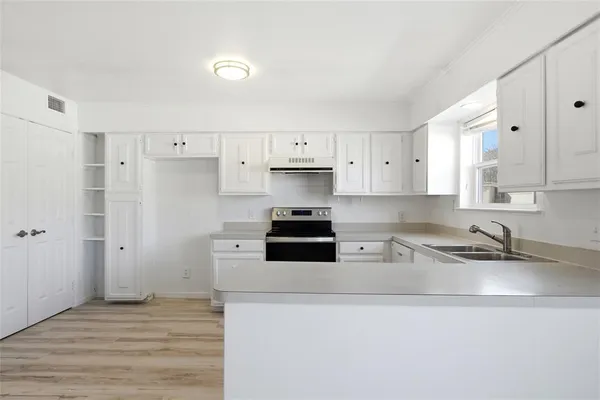 a kitchen with stainless steel appliances granite countertop a sink a stove and a refrigerator