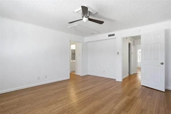 a view of empty room with wooden floor
