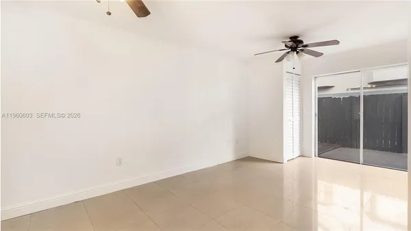 a view of a room with a ceiling fan and a window