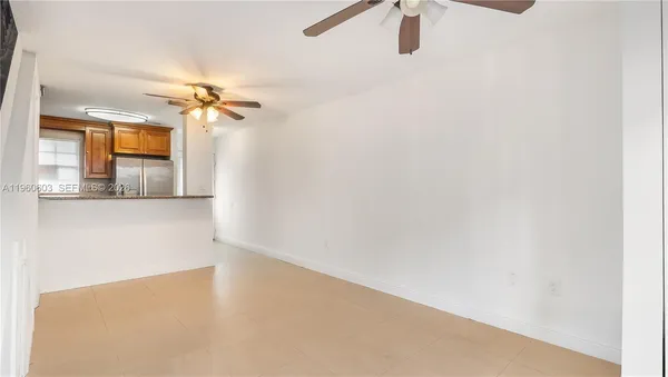a view of a room with a ceiling fan and wooden floor