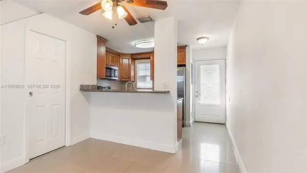 a view of a hallway with a dining table and chandelier