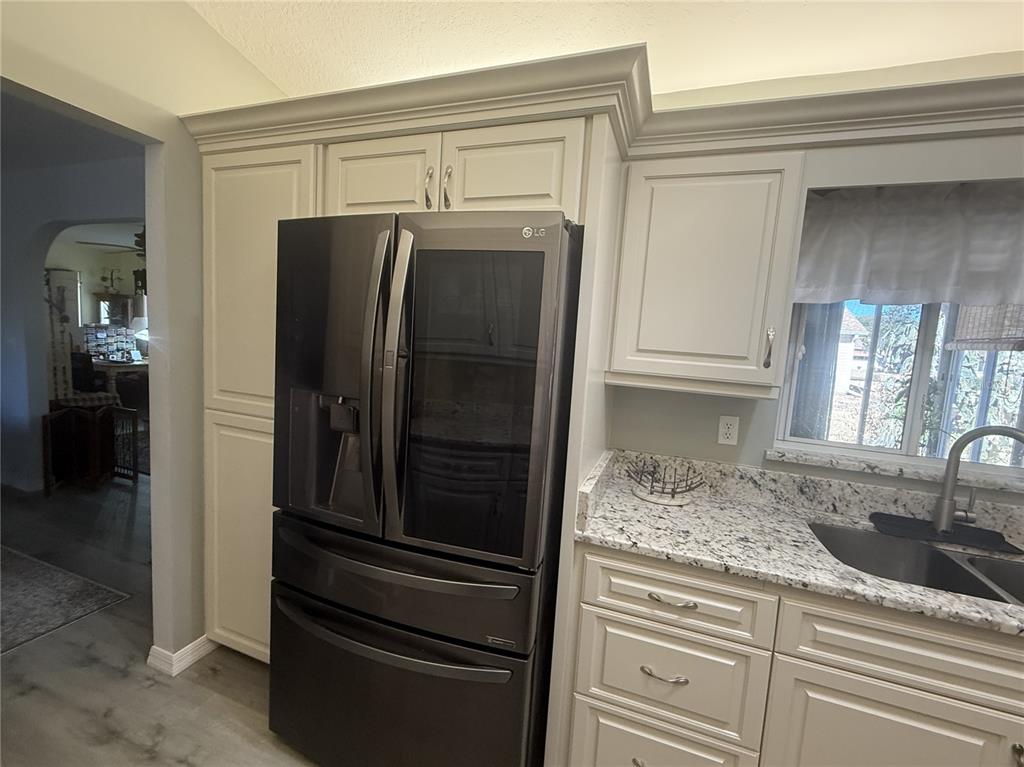 11263 Southwest 138th Lane Dunnellon, FL 34432 - Photo 5 of 25 a kitchen with granite countertop a refrigerator and a sink