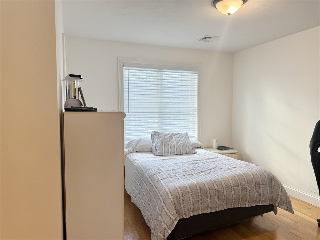 60 A Danforth Street, Unit A Taunton, MA 02780 - Photo 6 of 10 a bedroom with a bed and a chandelier