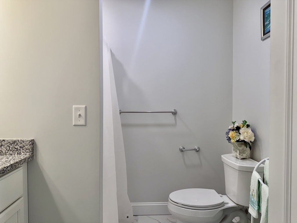 60 A Danforth Street, Unit A Taunton, MA 02780 - Photo 8 of 10 a white toilet sitting next to a bathroom sink and vanity