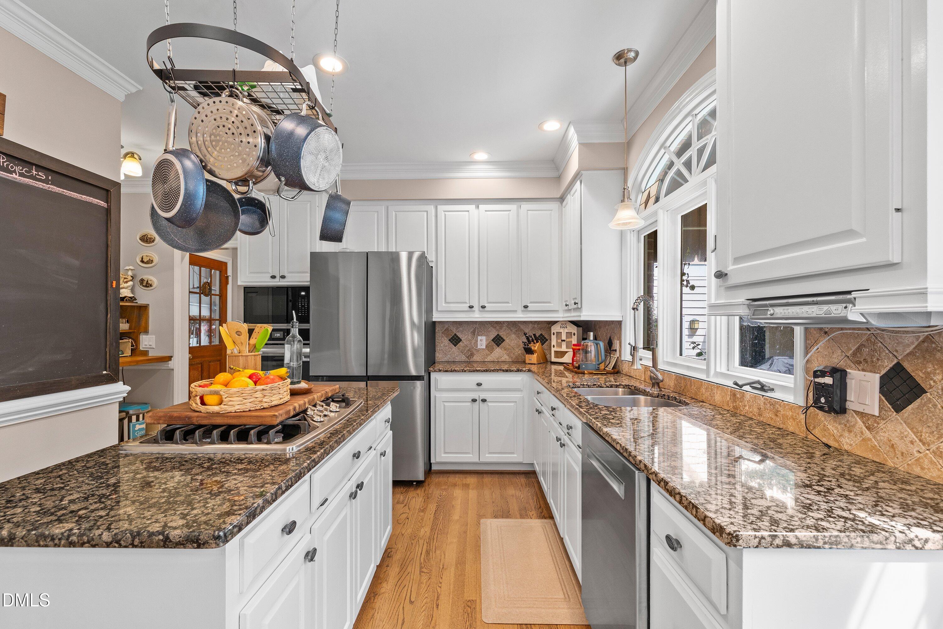 6612 Fowler Road Zebulon, NC 27597 - Photo 9 of 42 a kitchen with stainless steel appliances granite countertop a sink a stove and a refrigerator