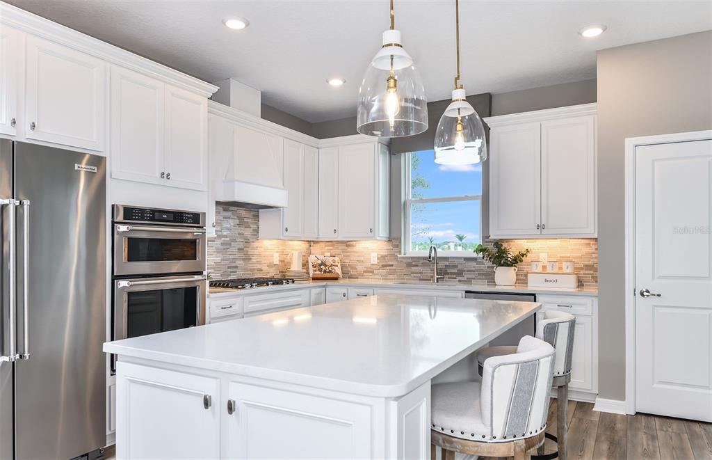 1320 Orange Vly Road Minneola, FL 34715 - Photo 9 of 23 a kitchen with a sink a kitchen island and stainless steel appliances