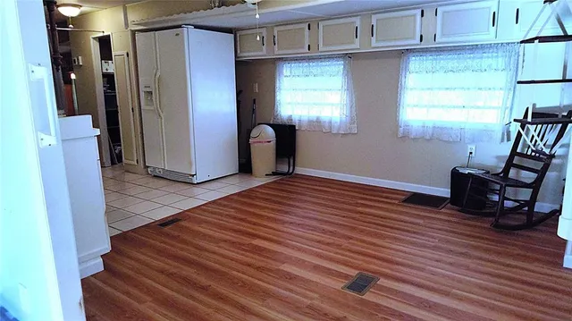 a view of an empty room with window and wooden floor
