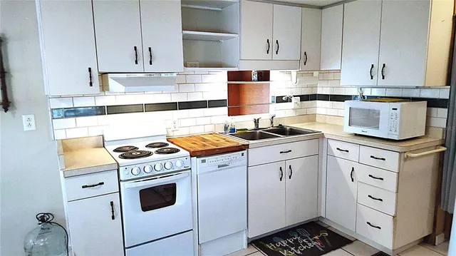 a kitchen with granite countertop white cabinets and white appliances