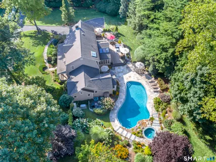 an aerial view of a house with a yard and a large tree