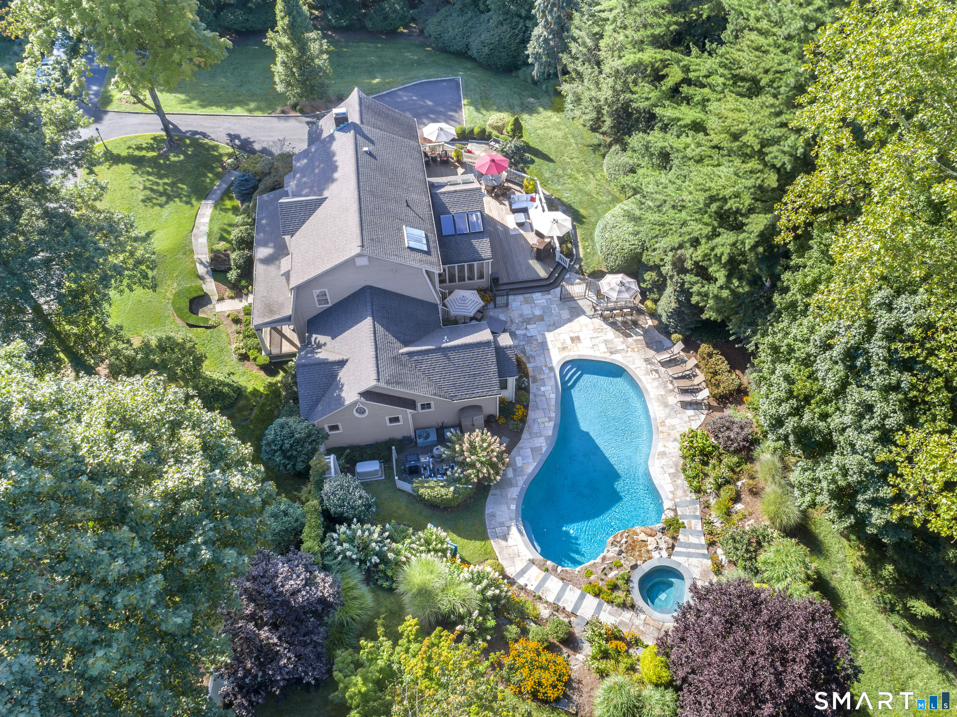 an aerial view of a house with a yard and a large tree
