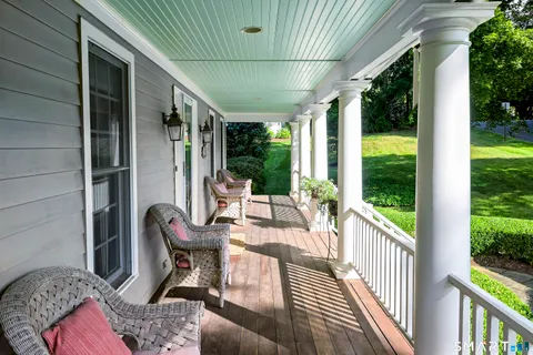 a view of a porch with furniture and a yard