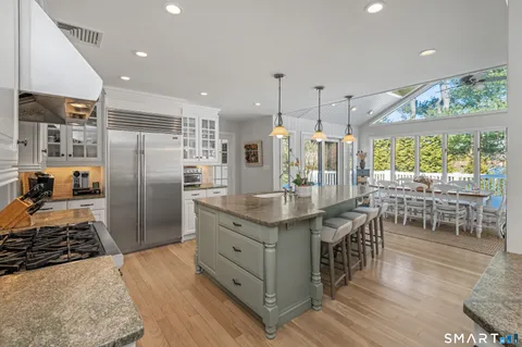 a kitchen with stainless steel appliances granite countertop a stove refrigerator and wooden floor