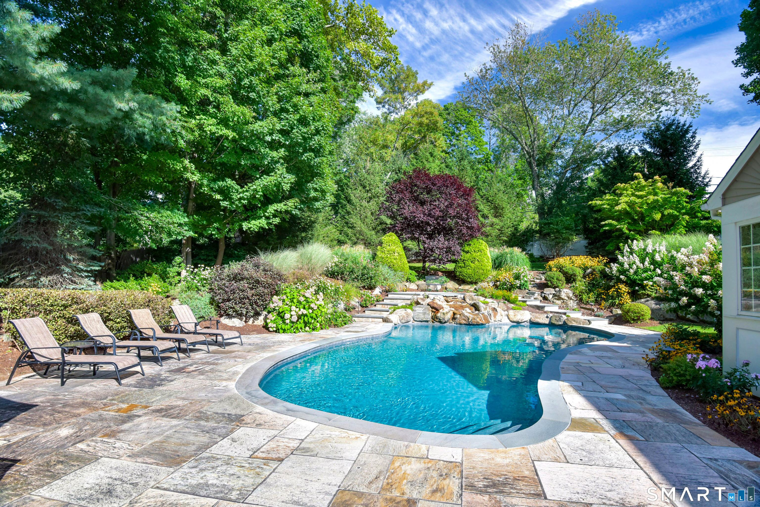 6 Sycamore Lane Ridgefield, CT 06877 - Photo 35 of 39 a view of a swimming pool with lawn chairs under an umbrella
