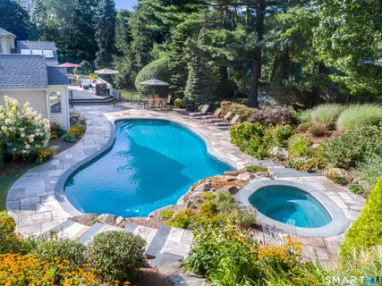 a view of a swimming pool with lawn chairs under an umbrella