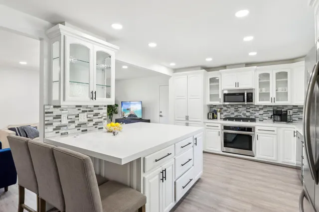 a kitchen that has a lot of cabinets in it and wooden floors